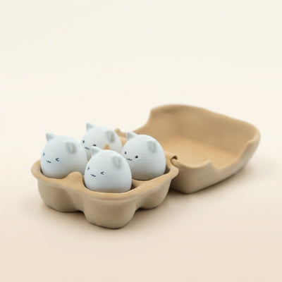 Eggie Meow Clicky Set of four egg-shaped cat face fidget toys in a brown carton with perky ears and cute expressions.